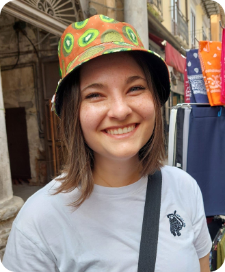 Julia wearing a colorful patterned hat and smiling